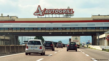 Autostrada con auto e area di servizio Autogrill